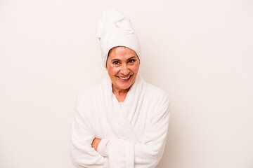 Middle age caucasian woman wearing a bathrobe isolated on white background laughing and having fun.
