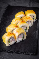 delicious sushi rolls on a black stone background