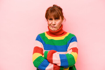 Middle age caucasian woman isolated on pink background frowning face in displeasure, keeps arms folded.