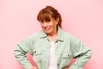 Middle age caucasian woman isolated on pink background confused, feels doubtful and unsure.