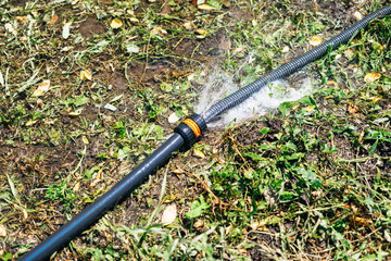 Wasting water - water leaking from hole in a hose