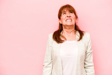 Fototapeta premium Middle age caucasian woman isolated on pink background shouting very angry, rage concept, frustrated.