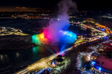 Aerial view of Horseshoe Falls winter illumination in twilight time. Niagara Falls City downtown...