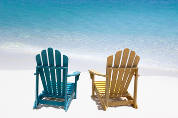 Two wooden beach chairs on white sand beach of  Caribbean coast