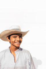 Vertical photo of a Male teenager with hat and traditional clothes from latin america smiling on white background