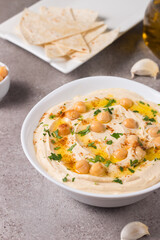 Hummus in a plate with chickpeas, smoked paprika, olive oil and pita. Vegetarian food.