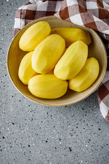 peeled potatoes on a gray stone background