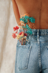 colorful preserved flowers in a girl's jeans