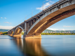 Fototapeta na wymiar Reinforced concrete bridge over a wide river. Cityscape.