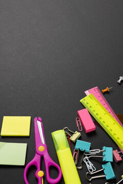 Imagine of various office supplies, pins, rulers, scissorson on black background