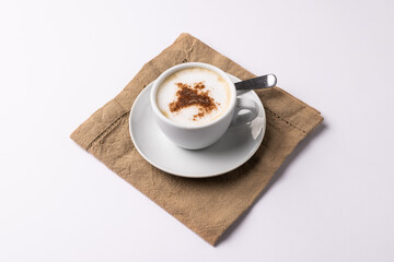 Image of white cup of coffee with milk and tea towel on white background