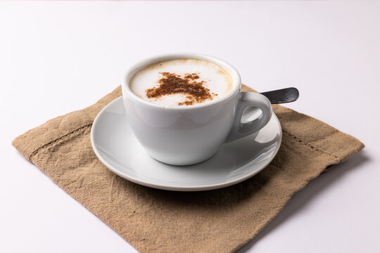 Image of white cup of coffee with milk and tea towel on white background