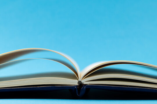 Image of open book with navy blue cover on blue background