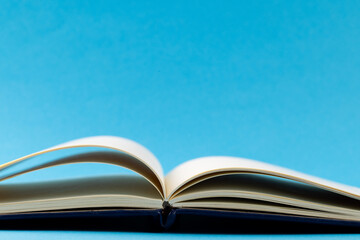 Image of open book with navy blue cover on blue background