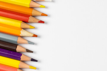 Composition of colorful crayons on white surface with copy space