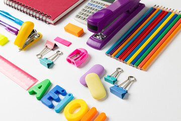 Composition of colorful school equipment with notebook and letters on white surface
