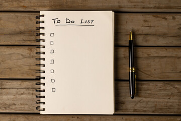 Image of notebook with to do list and copy space on wooden surface with pen