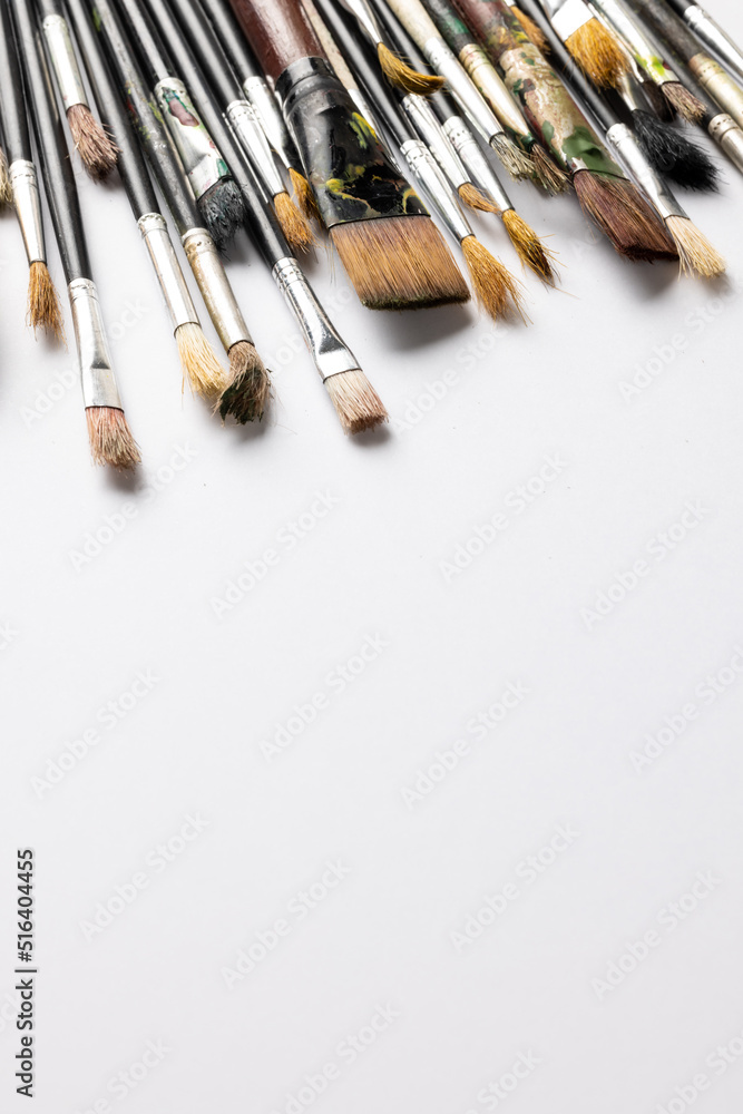Aufkleber vertical image of composition of diverse brushes on white surface with copy space