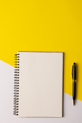 Image of notebook with copy space and pencil on yellow and white surface