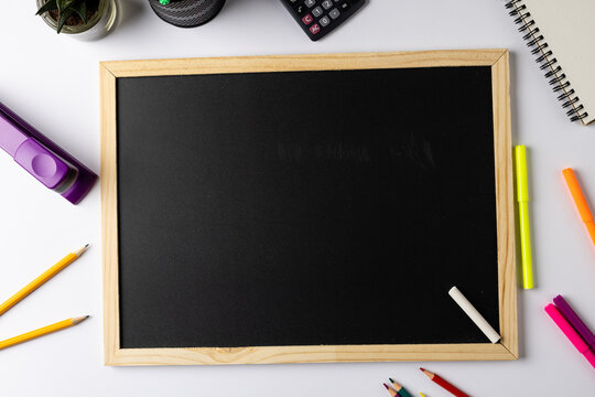 Image of black board with copy space and school items on white background