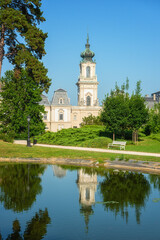 Fototapeta na wymiar Festetics Palace with beautiful garden on sunny summer day, baroque architecture, Keszthely, Zala, Hungary. Outdoor travel background with flowers, green grass, blue sky and pond with reflection