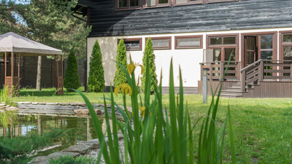 Beautiful landscaping with pond, plants and gazebo. Backyard garden landscaping. Landscape design.