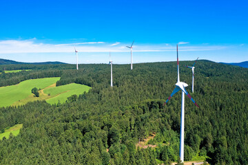 Aerial view of wind power plant in the bright green meadow and fir trees. St. Peter, Black forest, Germany.
Concept  for regenerative energy. - obrazy, fototapety, plakaty