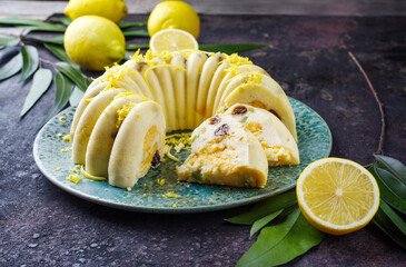 Traditional Italian budino di ricotta cheese pudding cake with raisins and lemon creme served as close-up on a design plate with cottage style decoration