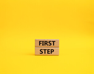 Naklejka premium First step symbol. Wooden blocks with words 'First step'. Beautiful yellow background. Business and 'First step' concept. Copy space.
