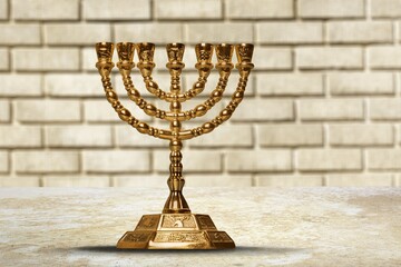 A classic gold menorah with a background of the walls
