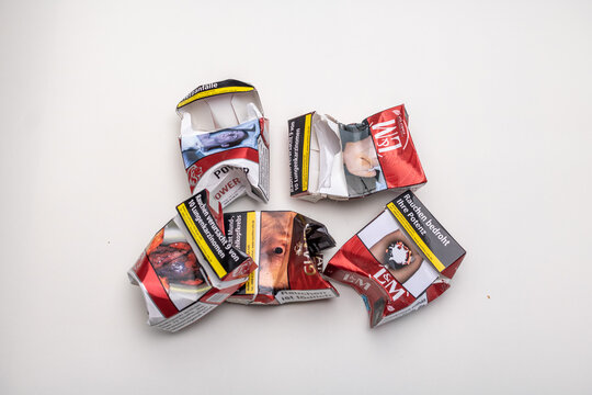 Neckargemuend, Germany: May, 13. 2022: several crumpled cigarette packs of different brands with warnings in German language as a symbol for smoking cessation and quitting smoking