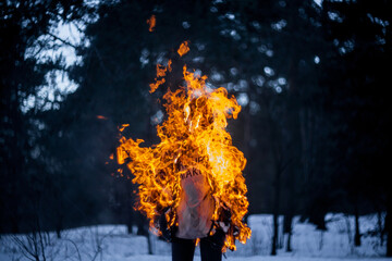 Burning clothing per person. A burning silhouette of a man. Image of a man on fire. Man on Fire. stuntman working on the fire. surrealism theme. Close-up portrait of a burning man.