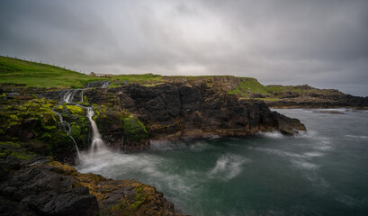 Fototapeta na wymiar long exposure view of the picturesque Irish coast and Dunseverick waterfall in summer