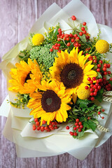 Beautiful autumn bouquet with sunflowers on abstract rustic wooden background. seasonal floristic...