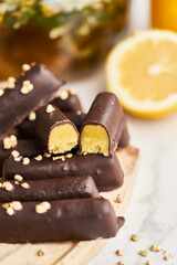 Nougat candies covered with chocolate glaze and nuts on white plate.  