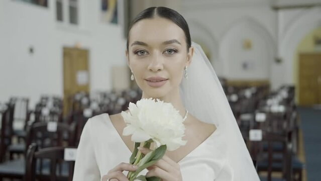 A beautiful bride. Action.Photographing in the registry office where they shoot a pretty girl with big eyes in a wedding white dress with a veil.