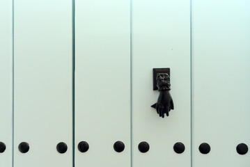 Turquoise wooden door has a black Hamsa or hand of Fatima shape Door knocker on it. Beautiful...
