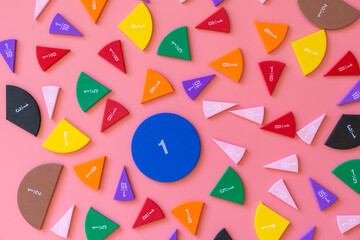 Violet orange yellow pieces of fractions on a table. Close up math material for study. Back to...