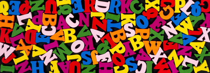 Obraz na płótnie Canvas Colorful Bright Wooden Letters on black Banner Background. Back to school concept.