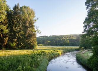 early moring landscape of fast flowing river ourthe in belgian ardennes region