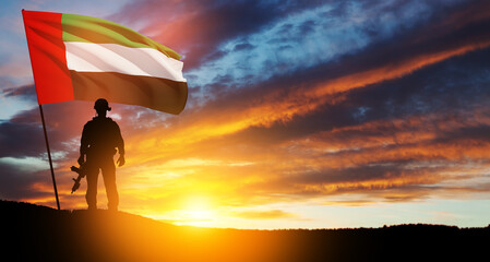 Silhouette of soldier with the flag of UAE against sunset or sunrise. Concept of national holidays....
