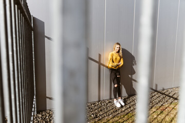 Young teenage girl leaning against metal facade