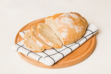 Assortment of freshly sliced baked bread with napkin on rustic table top view. Healthy unleavened bread. French bread slice