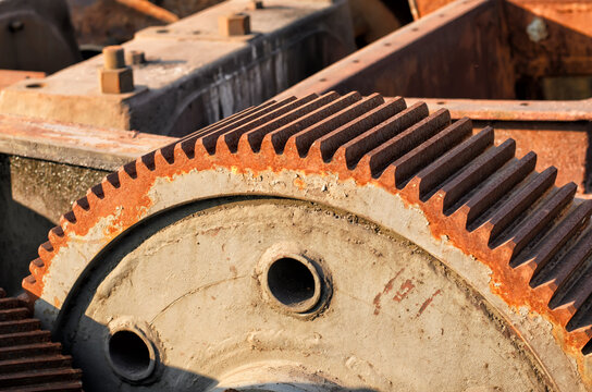 Massive cogwheel (gear wheel) of gray color and rusty metal industrial equipment, close-up