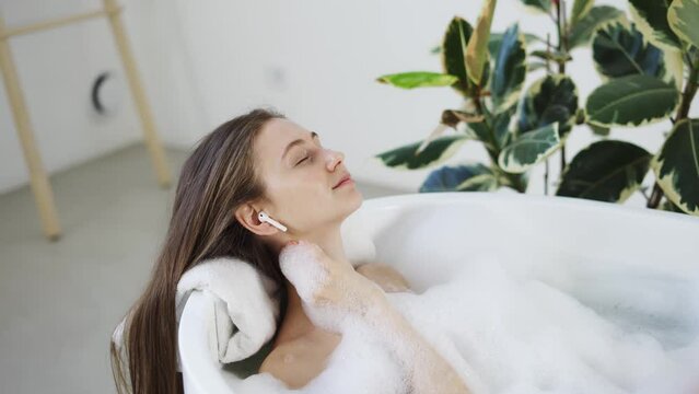 Woman In bath listen music in airpods