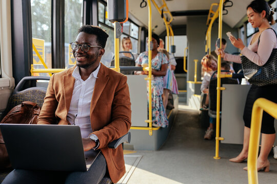 Young african american man working on laptop in bus