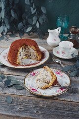 Traditional Italian Panettone cake stuffed with ricotta pudding, glanced fruits and raisins served as close-up on a classic design plate