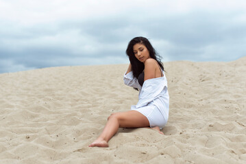 Fototapeta na wymiar Girl in the dunes on a cloudy day