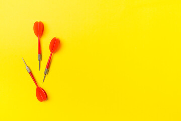 Red darts on color background, top view