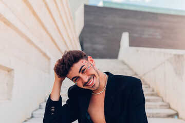 Cheerful feminine man with rhinestones on face